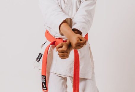 Cross-Training - A woman in a white karate outfit holding a red belt