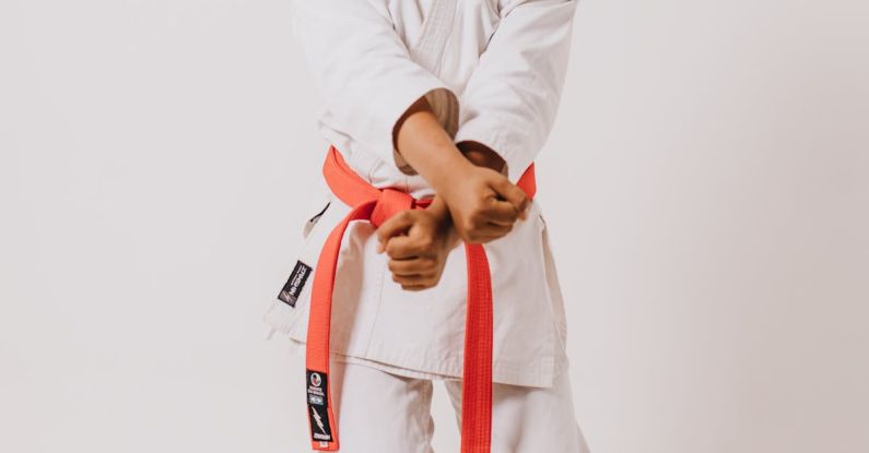 Cross-Training - A woman in a white karate outfit holding a red belt